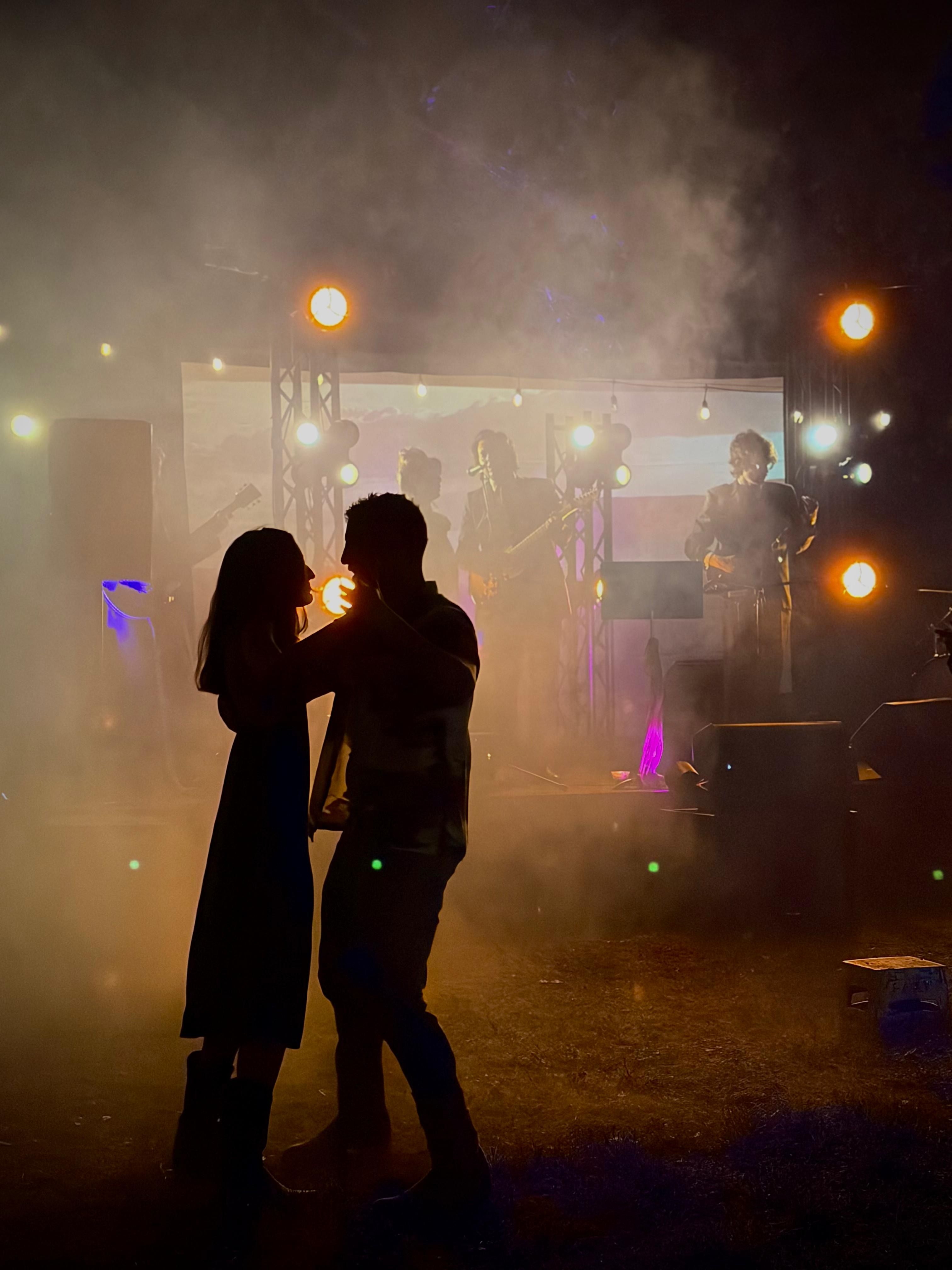 Couple dancing with string lights overhead