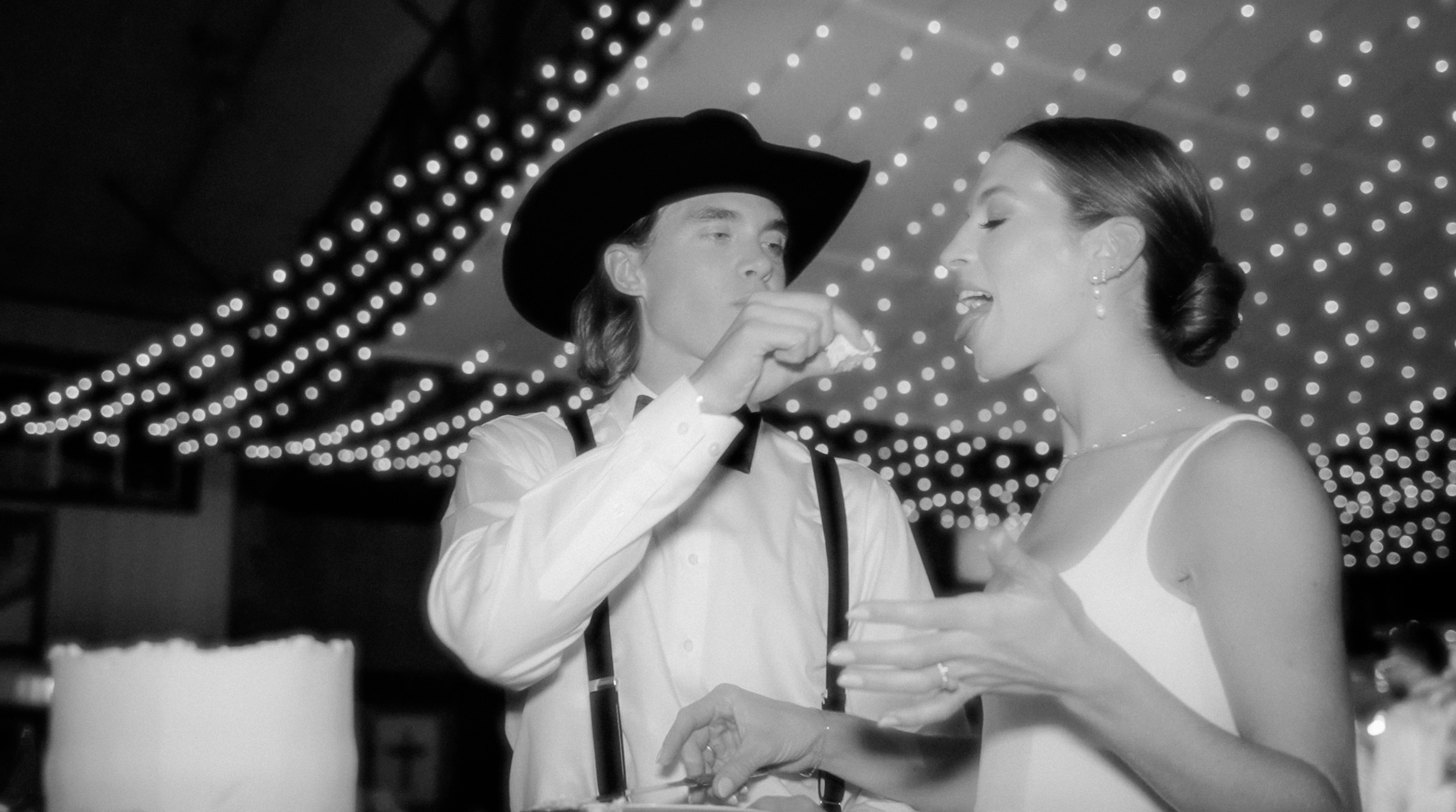 Wedding couple under string lights, black and white
